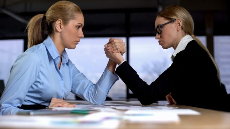 Businesses compete (two ladies arm wrestling)