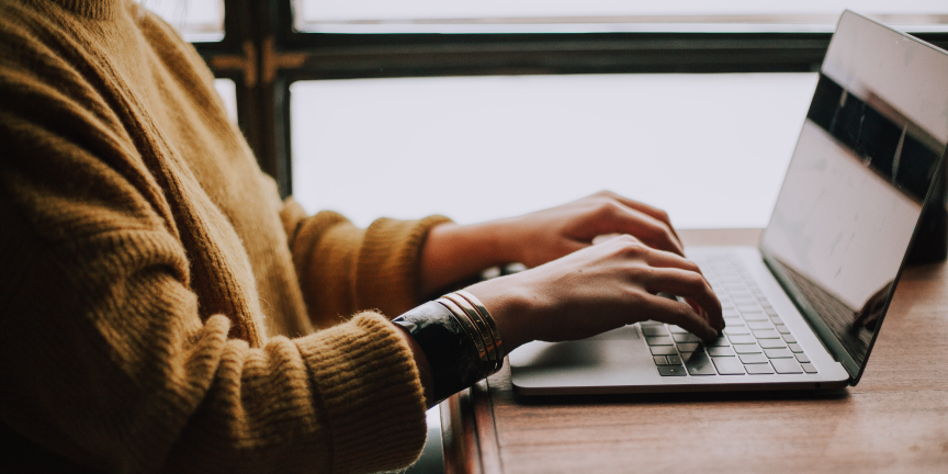 Close up of a woman typing on a laptop