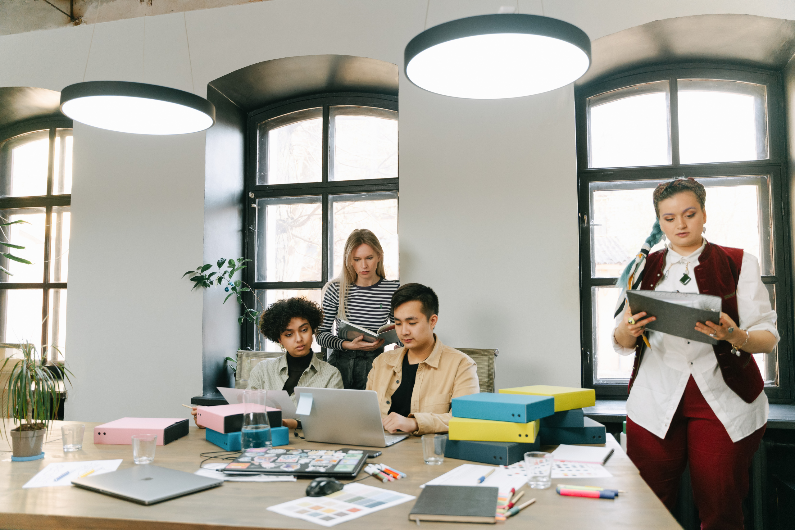 Coworkers collaborating at a shared table, representing modern workplace dynamics and retention challenges.