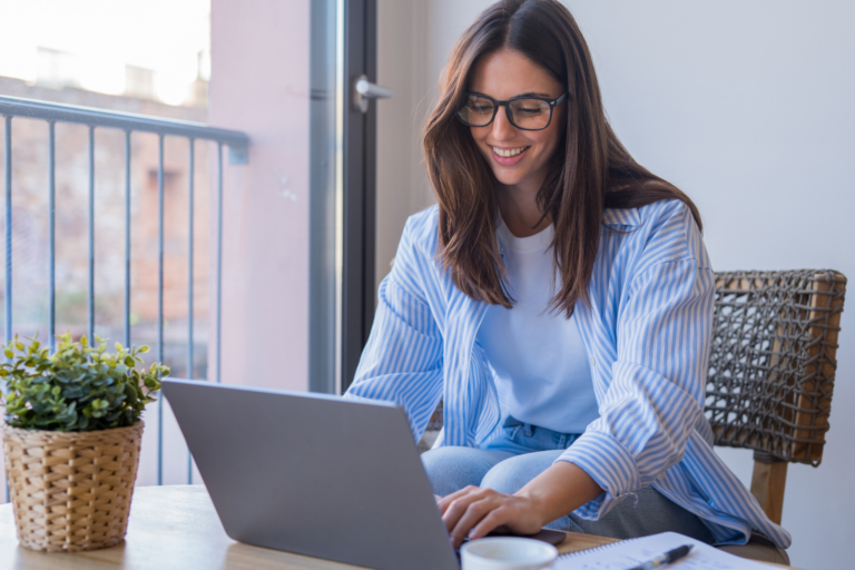 Happy Gen Z professional working on a laptop in a home office environment