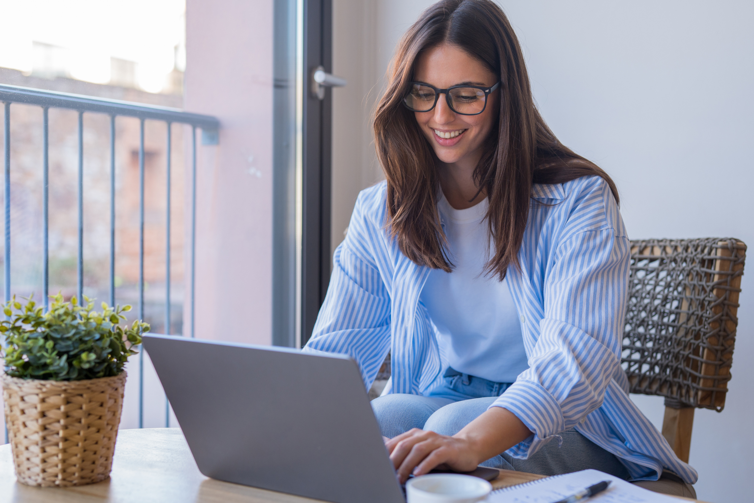 Happy Gen Z professional working on a laptop in a home office environment