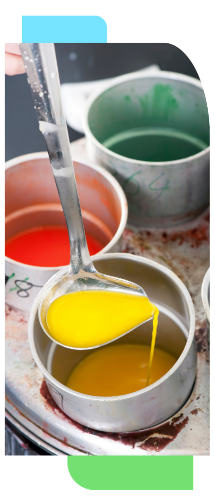 Close-up of paint being poured from a metal ladle into a container.